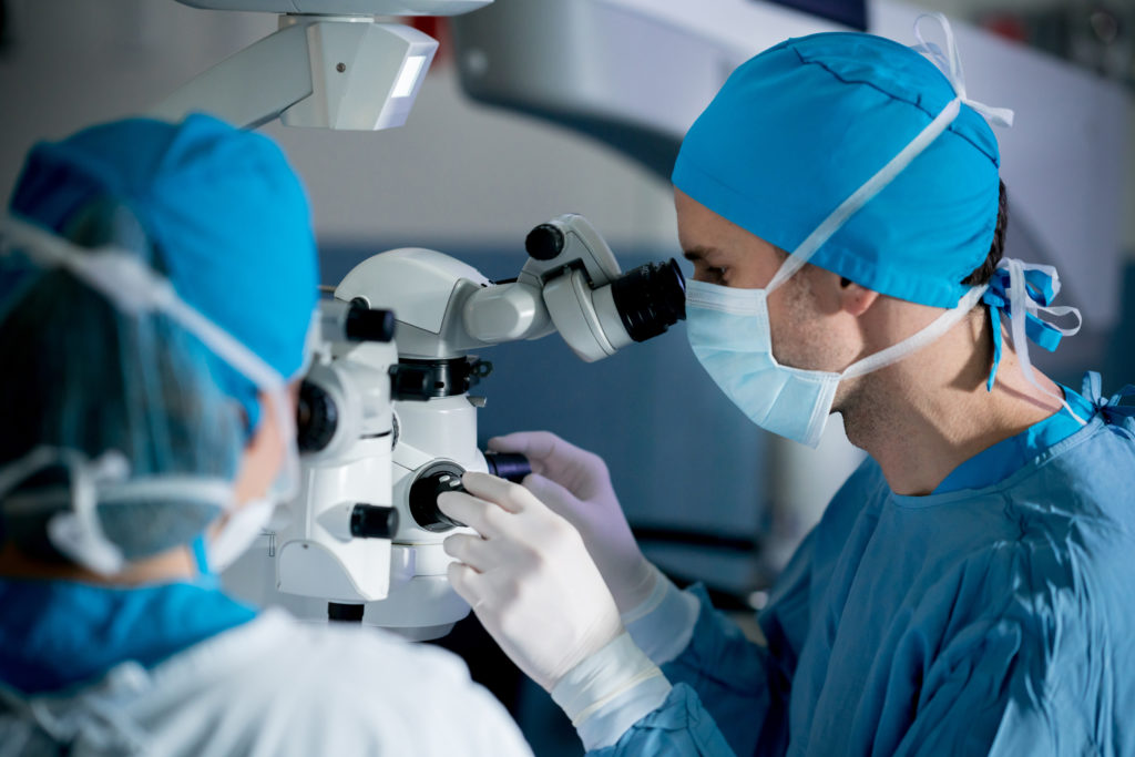 An eye surgeon with her assistant optimizing a LASIK device.