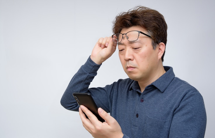 Man trying to read something on his mobile phone. poor sight, presbyopia