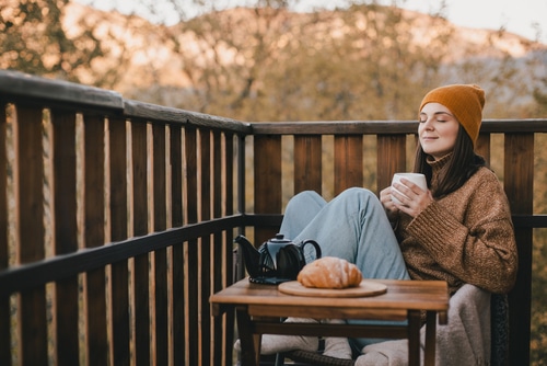 Woman sitting outside with coffee and pastry