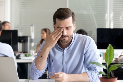 Man in office setting experiencing dry eye